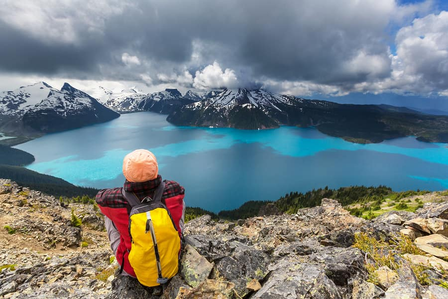 a person sitting on a trail overlooking the lake