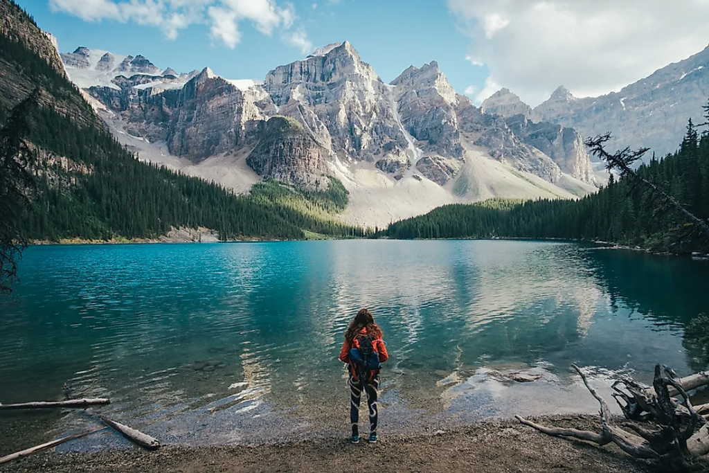 a girl standing in front of a lake in canada